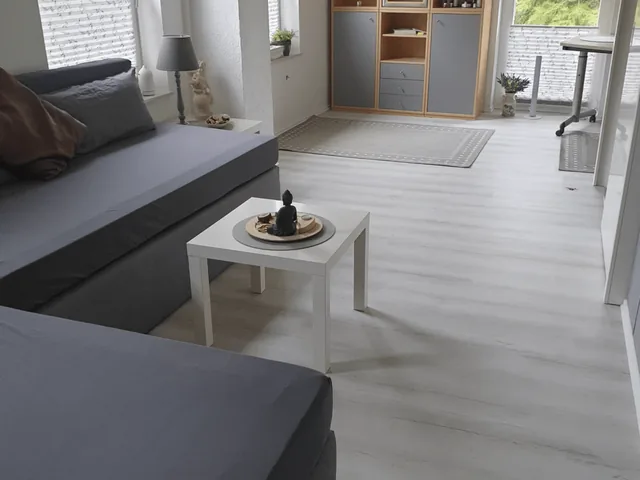 Graues Ecksofa mit weißem Beistelltisch in einem hellen Raum